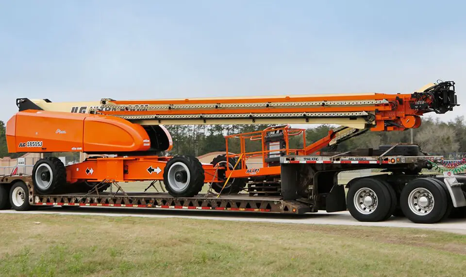 A photo of construction equipment loaded on to a trailer.