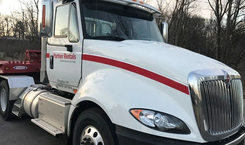 A Partner Rentals tractor trailer for hauling equipment.