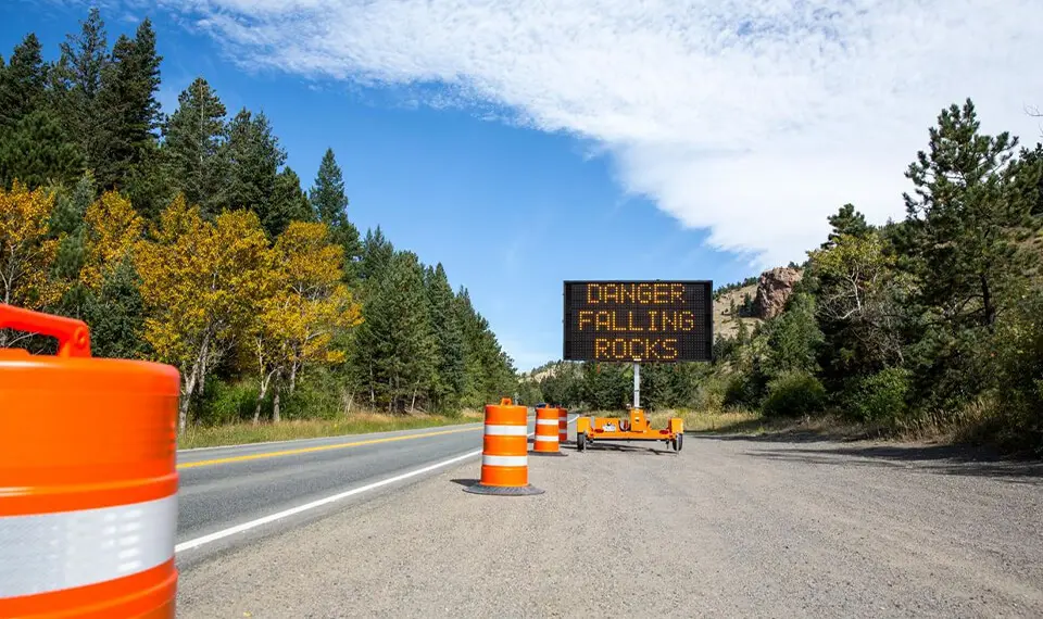 A photo of an electronic message board with the warning 'Danger Falling Rocks'