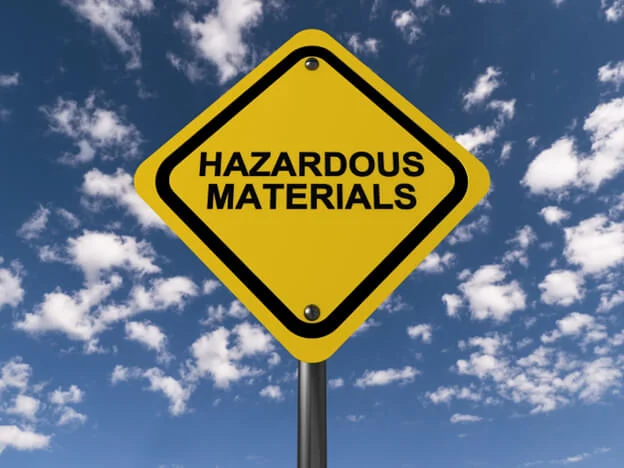 A yellow road sign that reads 'Hazardous Materials'.