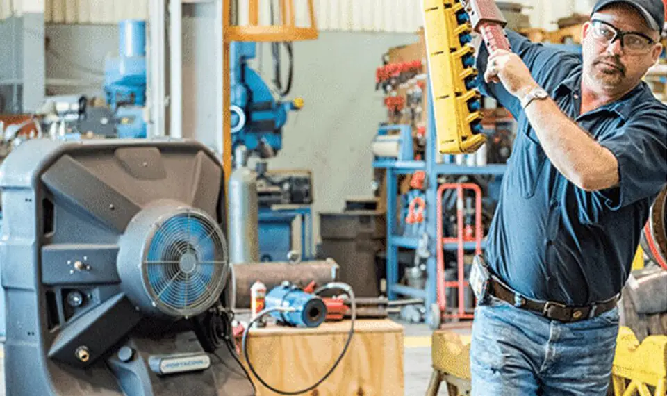 A photo of an employee working in a machine shop with an air conditioner.