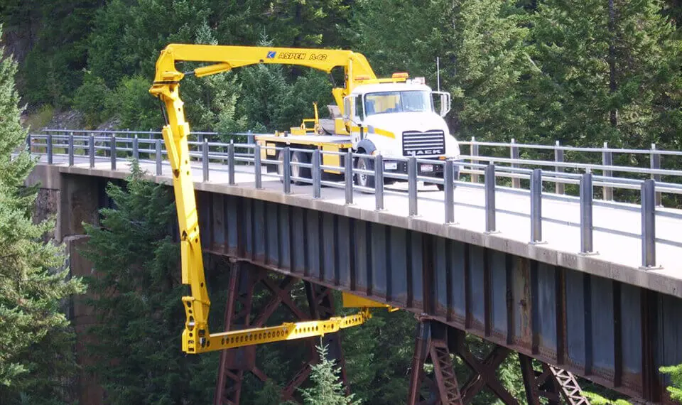 A photo of an under bridge inspection truck in use on a bridge.