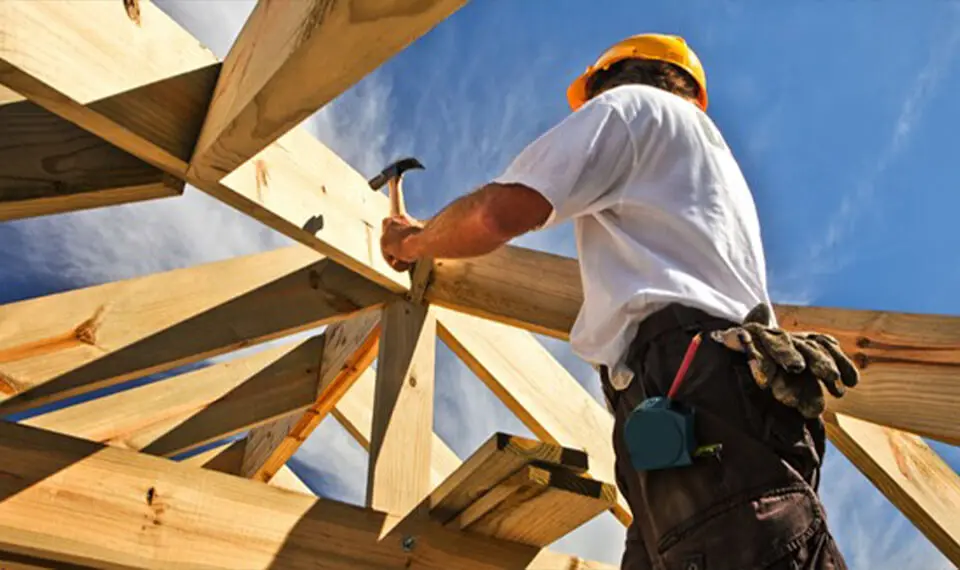 A photo of a carpenter using a hammer.