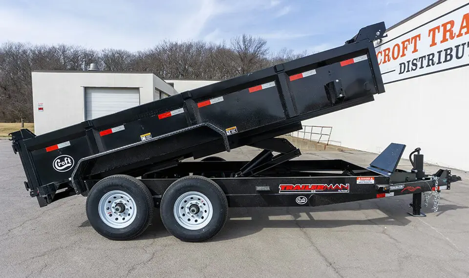 A photo of an end dump trailer with its box elevated.