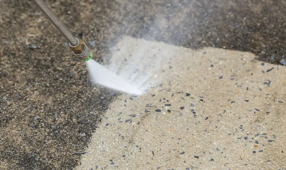 A photo of a concrete surface being pressure washed.