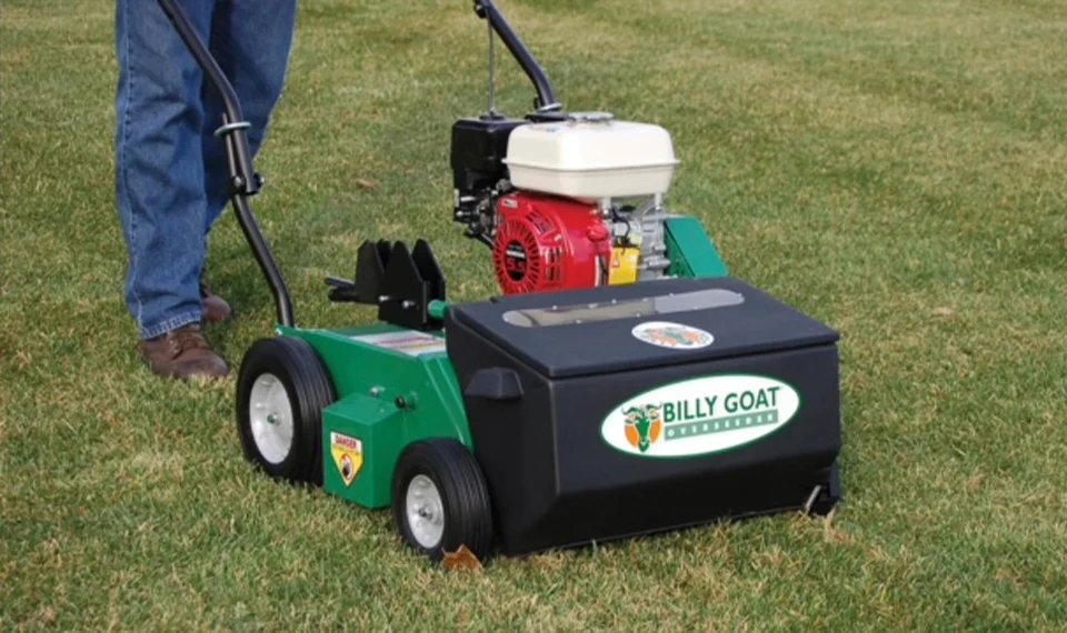 An individual using an overseeder on their lawn.