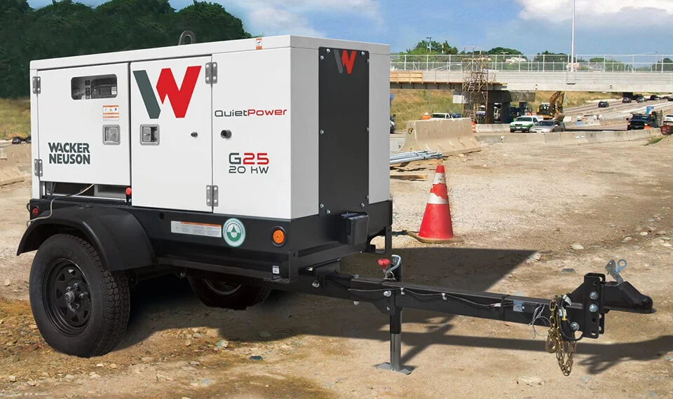 A towable generator parked at a construction site.