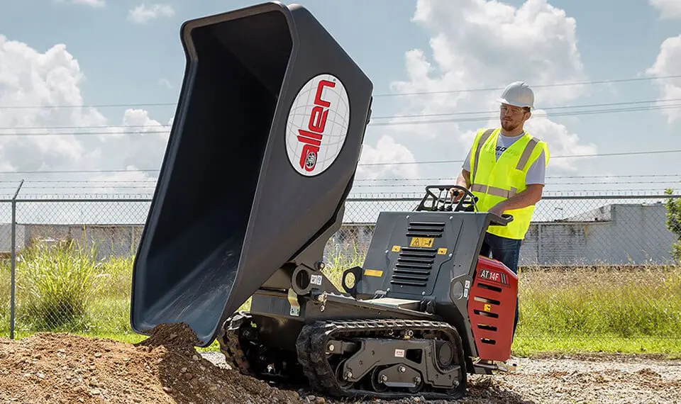 A construction worker using a material buggy to move dirt.