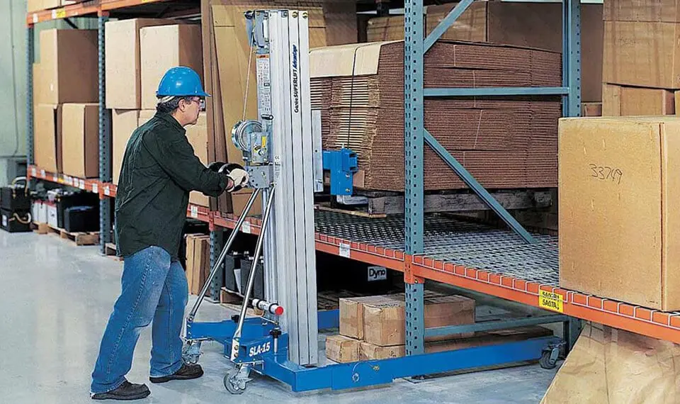 A worker using a material lift to move inventory in a warehouse.