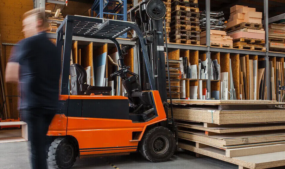 A photo of a forklift parked in a warehouse.