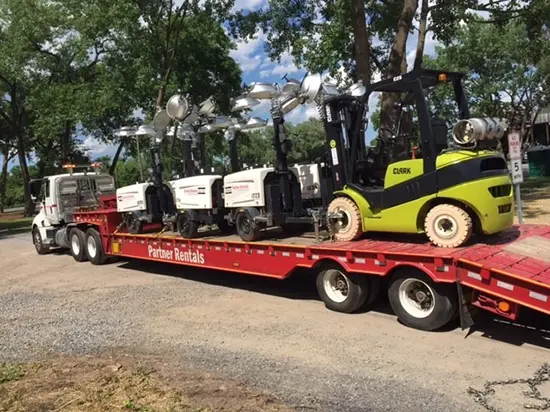 A photo of a flatbed truck hauling equipment.