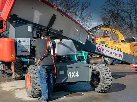 A photo of a technician servicing a piece of rental equipment.